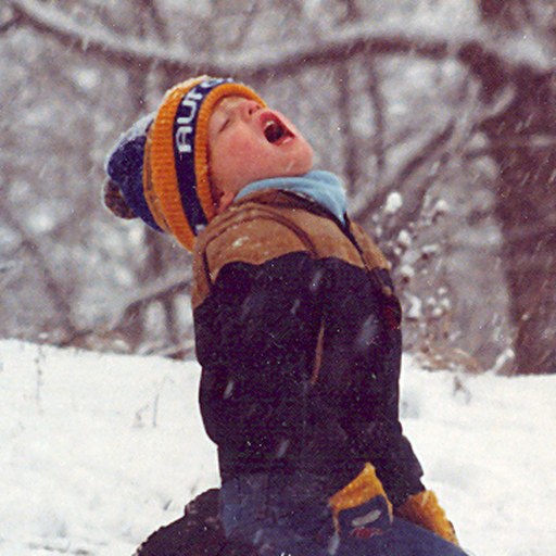 Brent Norris as a kid, catching snowflakes on a sled